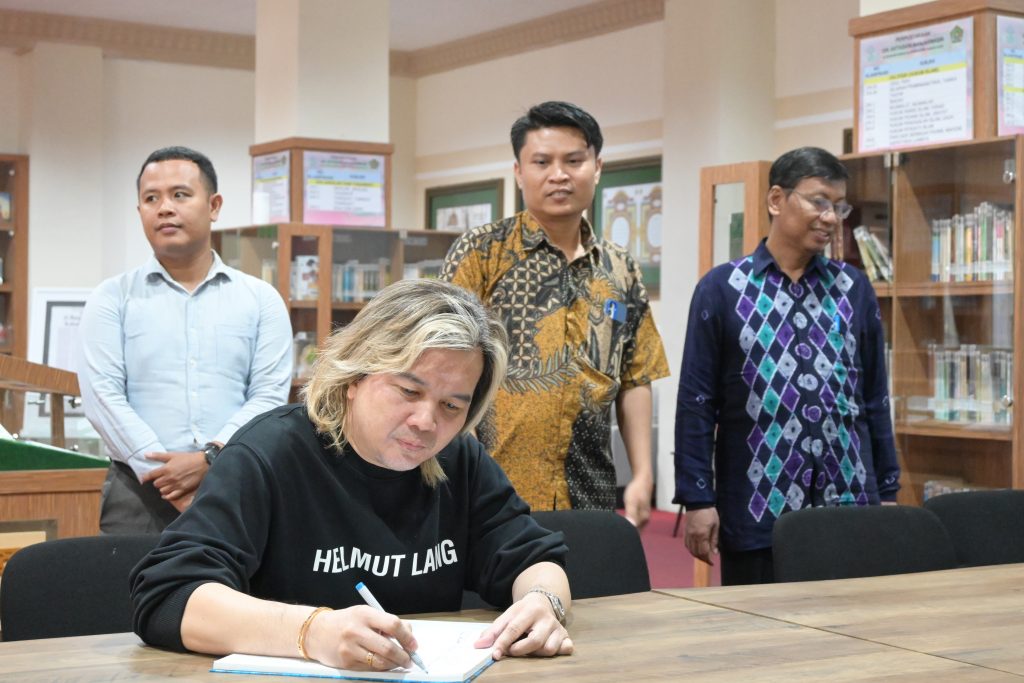 Dr. Azhar Ibrahim dari Singapura saat mengisi buku tamu (Foto:Humas/Achmad Magfur)