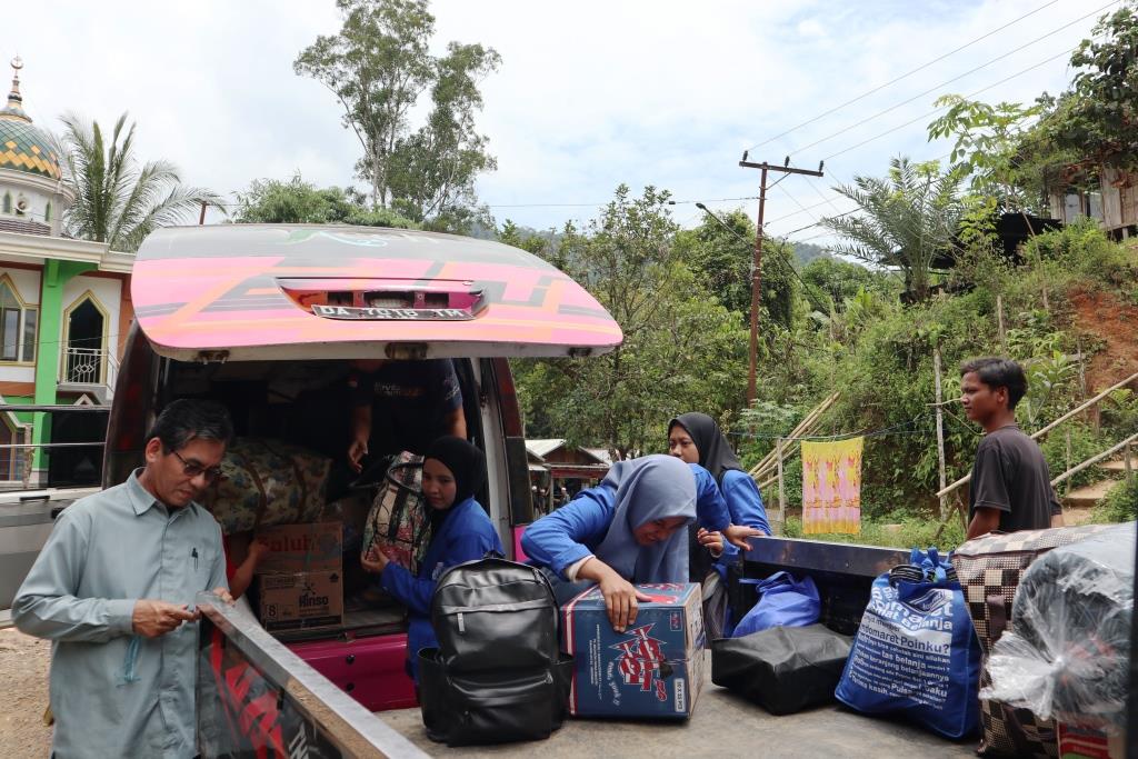 Drs. H. Muhammad Yusuf, M.Fil.I., Dosen Pembimbing Lapangan saat membantu proses pengangkutan barang-barang mahasiswa KKN (Foto:Humas/Achmad Magfur)