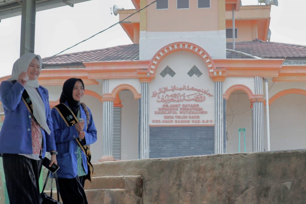 Dua Putri UIN Antasari berjalan keluar Pesantren Raudatul Mutaallimin usai menuntaskan sosialisasi.