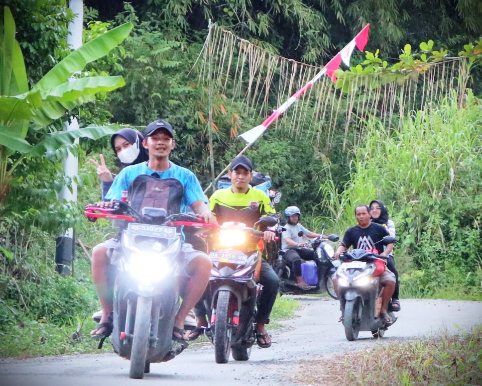 Para mahasiswa KKN saat diantar warga menggunakan sepeda motor menuju Dusun Baringan (Foto:Humas/Achmad Magfur)