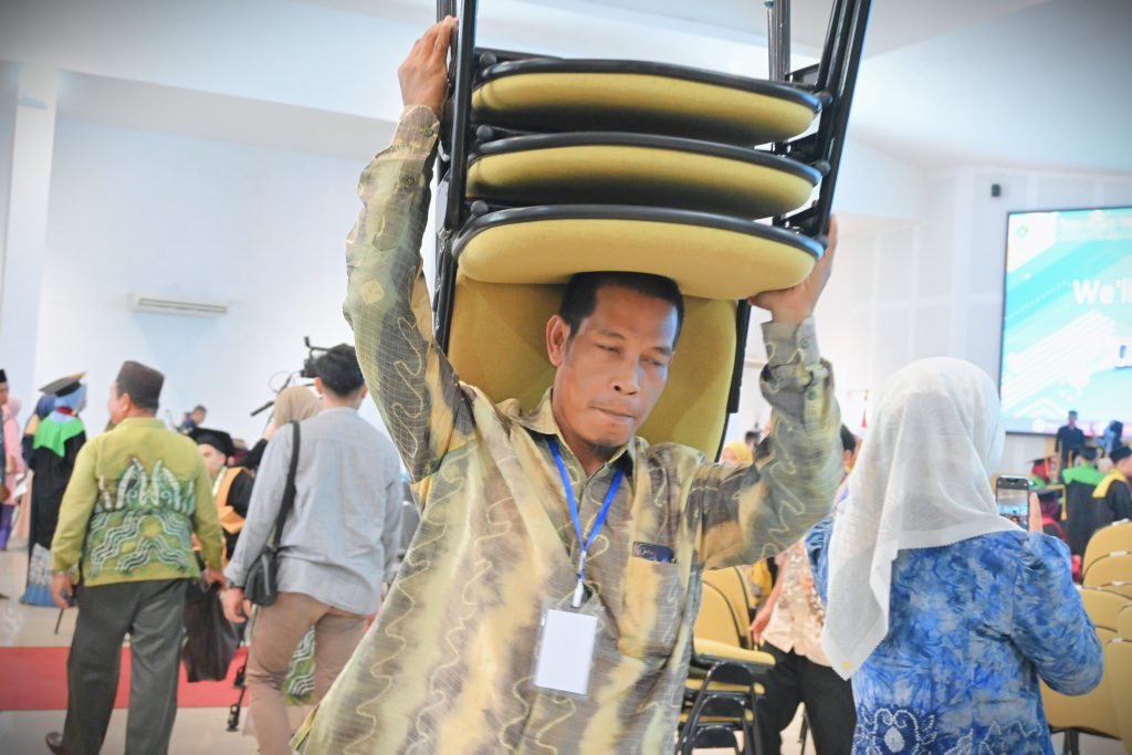 Totalitas Umar Prasetyo saat menyiapkan kenyamanan peserta mengikuti wisuda (Foto:Humas/Jamal Ripani)