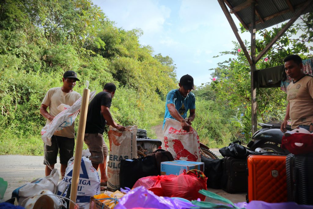 Warga saat membantu pengangkatan barang-barang mahasiswa ke sepeda motor (Foto:Humas/Achmad Magfur)