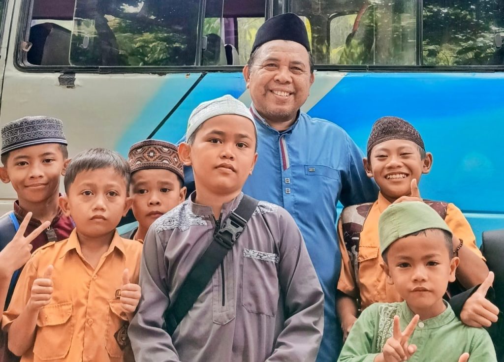 Dosen Pembimbing Lapangan KKN Desa Batu Ampar Dr. M. Ramli AR, M.Pd. saat berfoto bersama anak-anak Desa Batu Ampar.