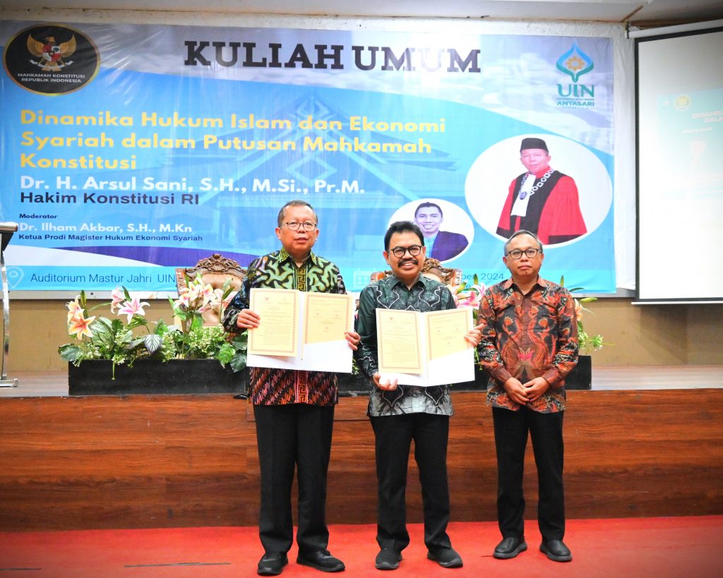 Hakim Konstitusi RI dan Rektor UIN Antasari didampingi Wakil Rektor Dr. Irfan Noor saat memperlihatkan MoU yang ditandatangani (Foto:Humas/Jamal Ripani)