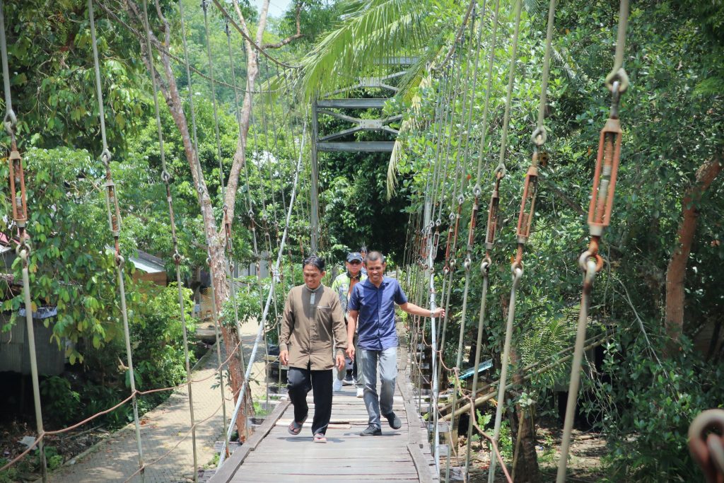 Melewati Jembatan Gantung Datar Belimbing Desa Hulu Banyu (Foto:Humas/Achmad Magfur)