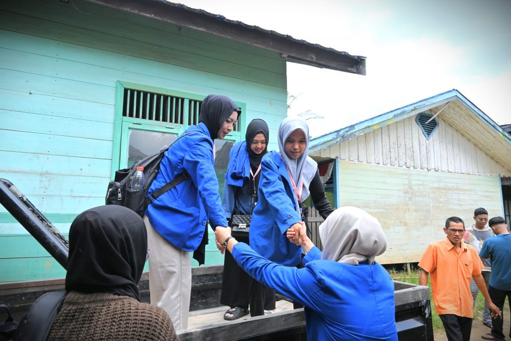 Para mahasiswi saat menaiki mobil pikap menuju lokasi pengabdian.