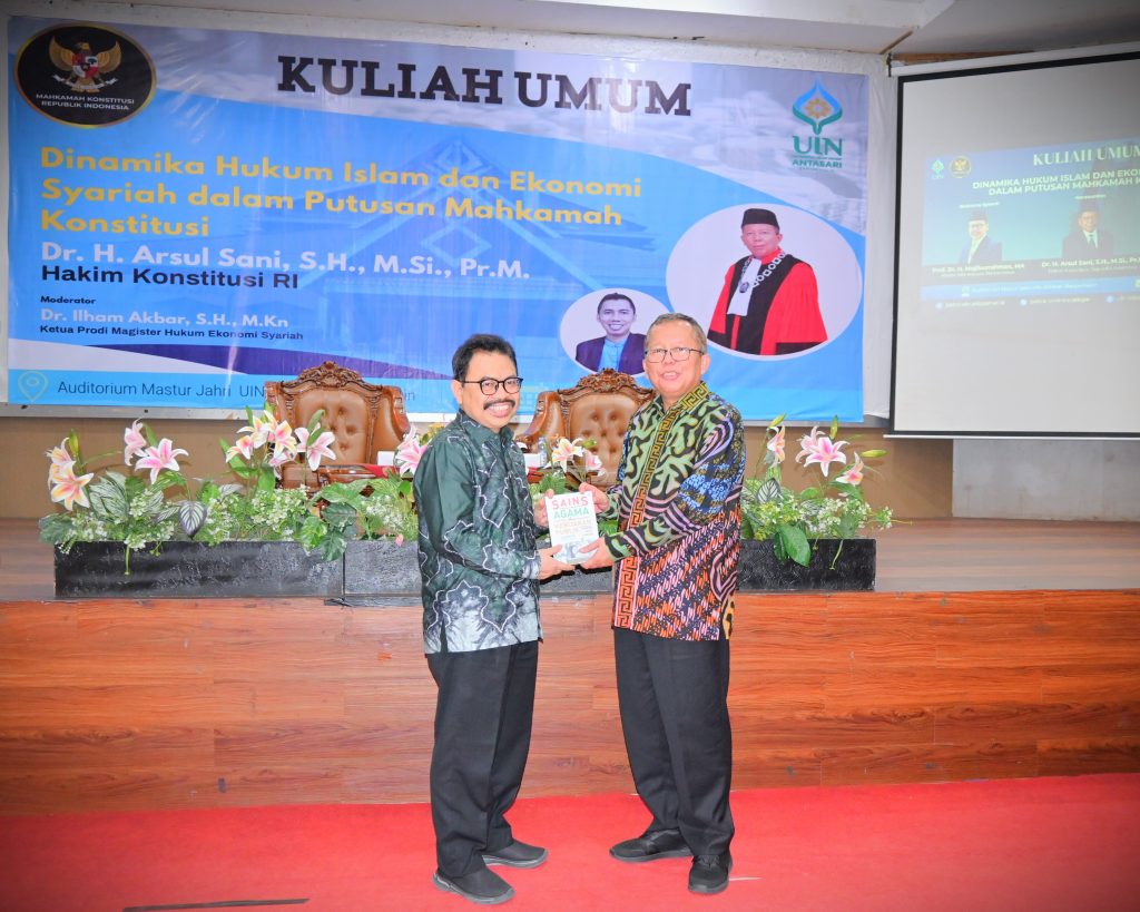 Rektor UIN Antasari saat menyerahkan kenang-kenangan karya bukunya kepada Hakim Konstitusi RI (Foto:Humas/Jamal Ripani)