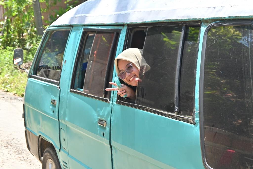 Salah satu mahasiswa KKN Kecamatan Piani saat ceria menuju lokasi pengabdian.