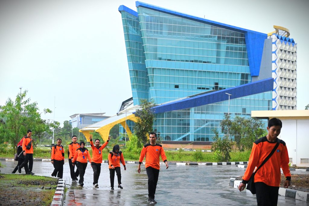 Para peserta melewati gerimis menuju lokasi pelatihan di Gedung Serbaguna Kampus 2 (Foto:Humas)