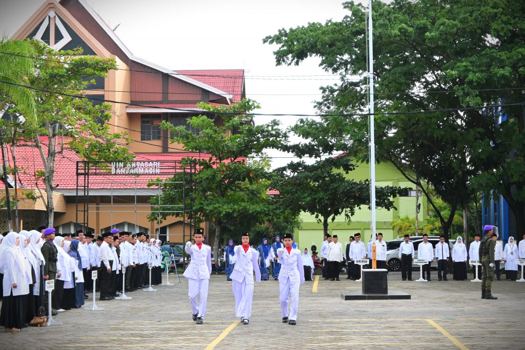 Tiga mahasiswa usai menuntaskan tugasnya mengibarkan bendera di Upacara Peringatan HAB ke-79 Kemenag RI di UIN Antasari (Foto:Humas/Baiti Rahmi)