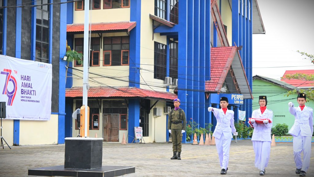 Trio mahasiswa saat bersiap mengibarkan bendera (Foto:Humas)