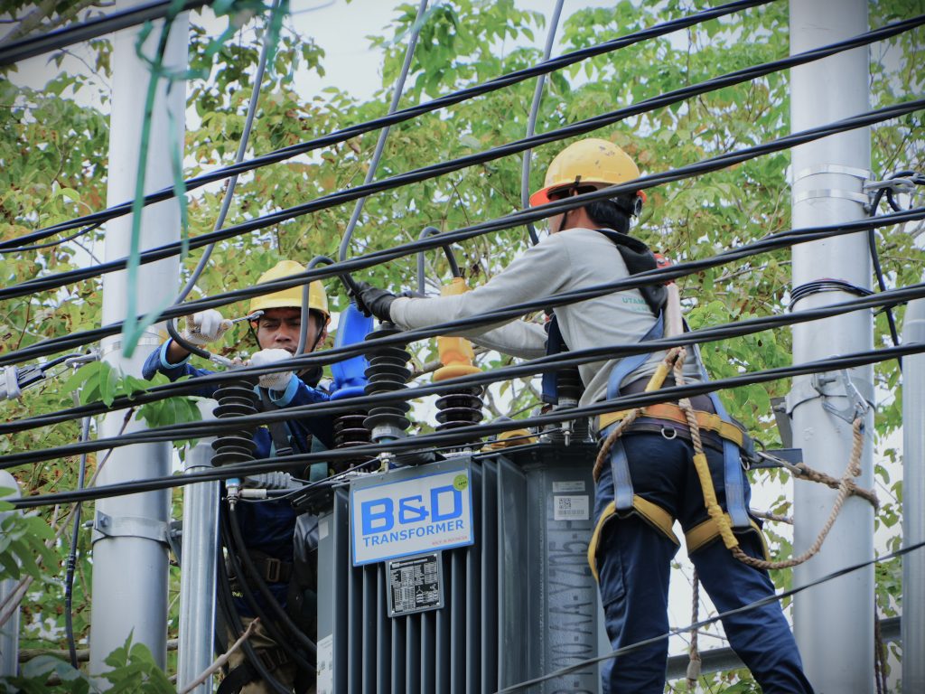 Dua pekerja saat sedang melepas baut dan kabel-kabel di trafo lama (Foto:Humas)