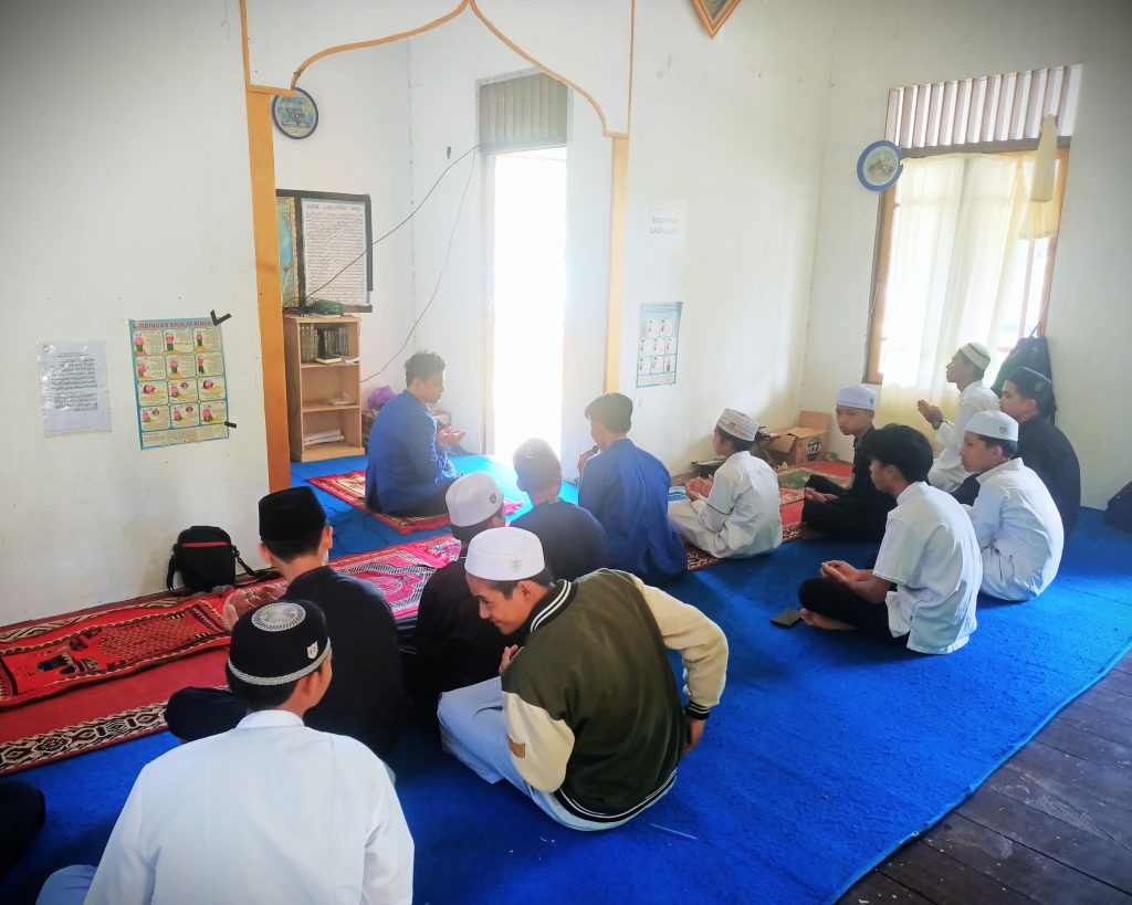 Mahasiswa KKN saat memimpin bimbingan salat berjemaah.